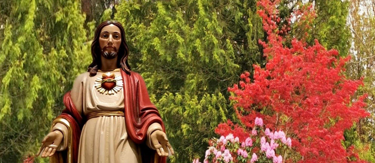 Sacred Heart statue of Jesus in a field of flowers